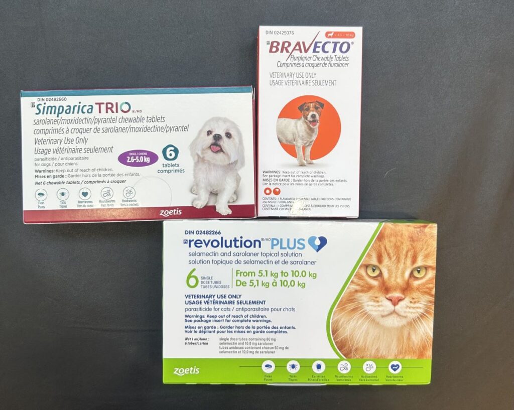 Three boxes of flea and tick brands in front of a black backdrop